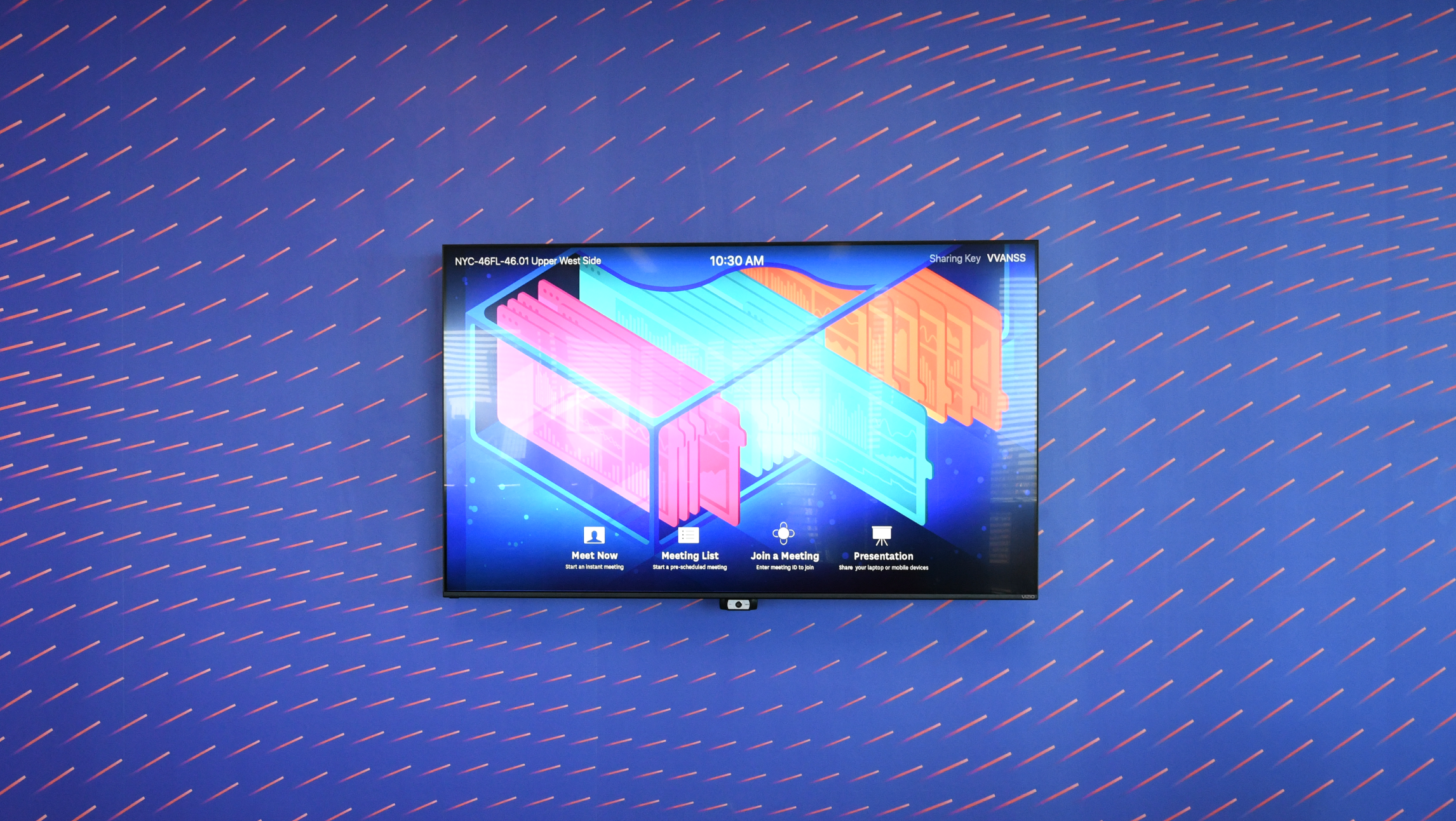 A photograph of a television mounted on a wall. The wall has a blue wallpaper with many small peach dashes arranged at varying angles.